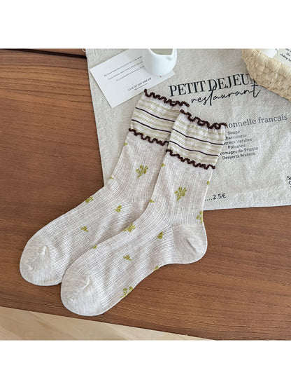 Pair of Rufia floral crew socks displayed flat with frill edges visible
