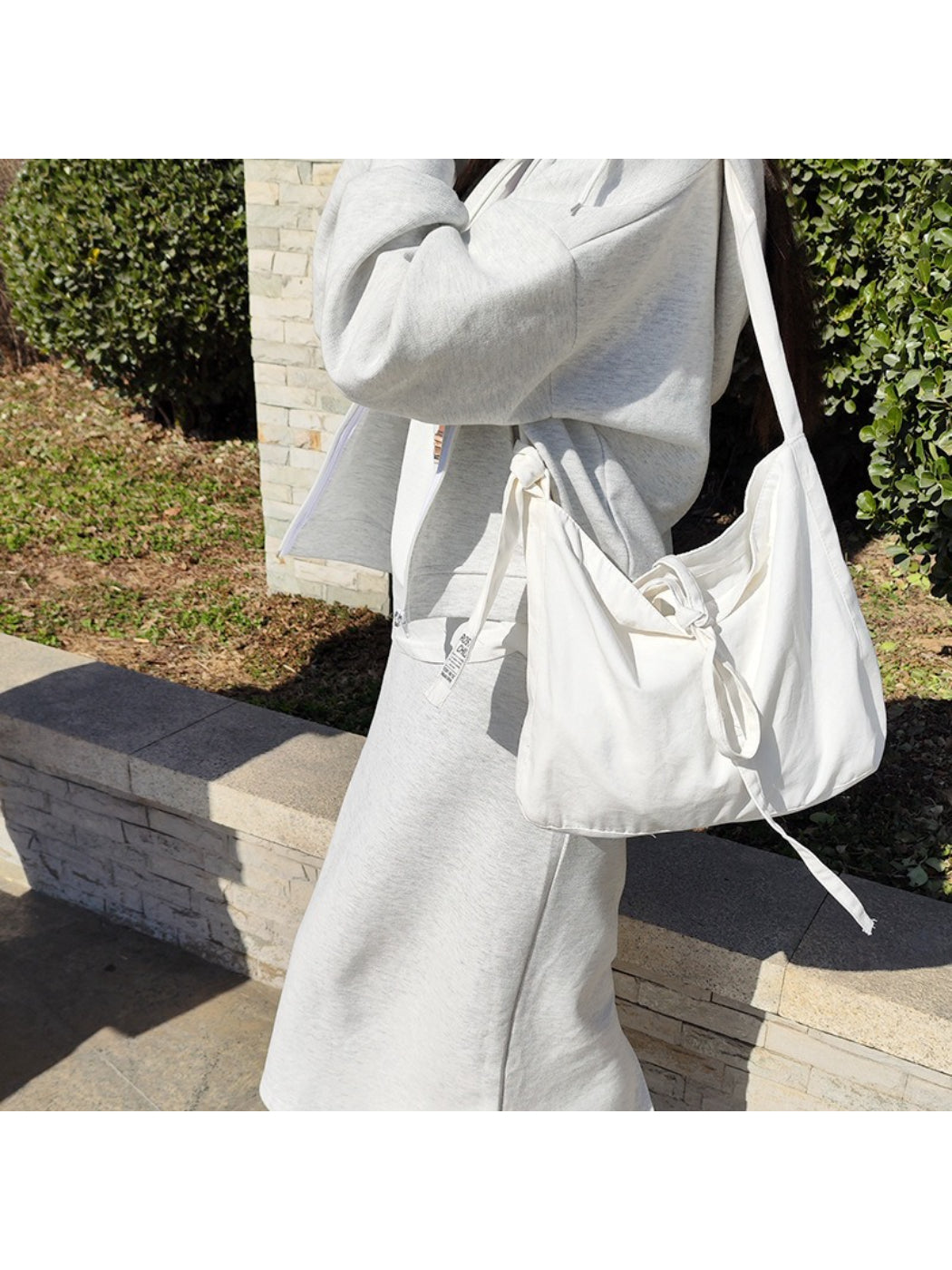 Close-up of tied shoulder strap detail on Cosbai slouchy bag in beige