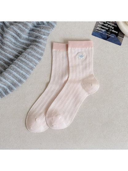 Flat lay of pastel socks with heart motifs arranged neatly