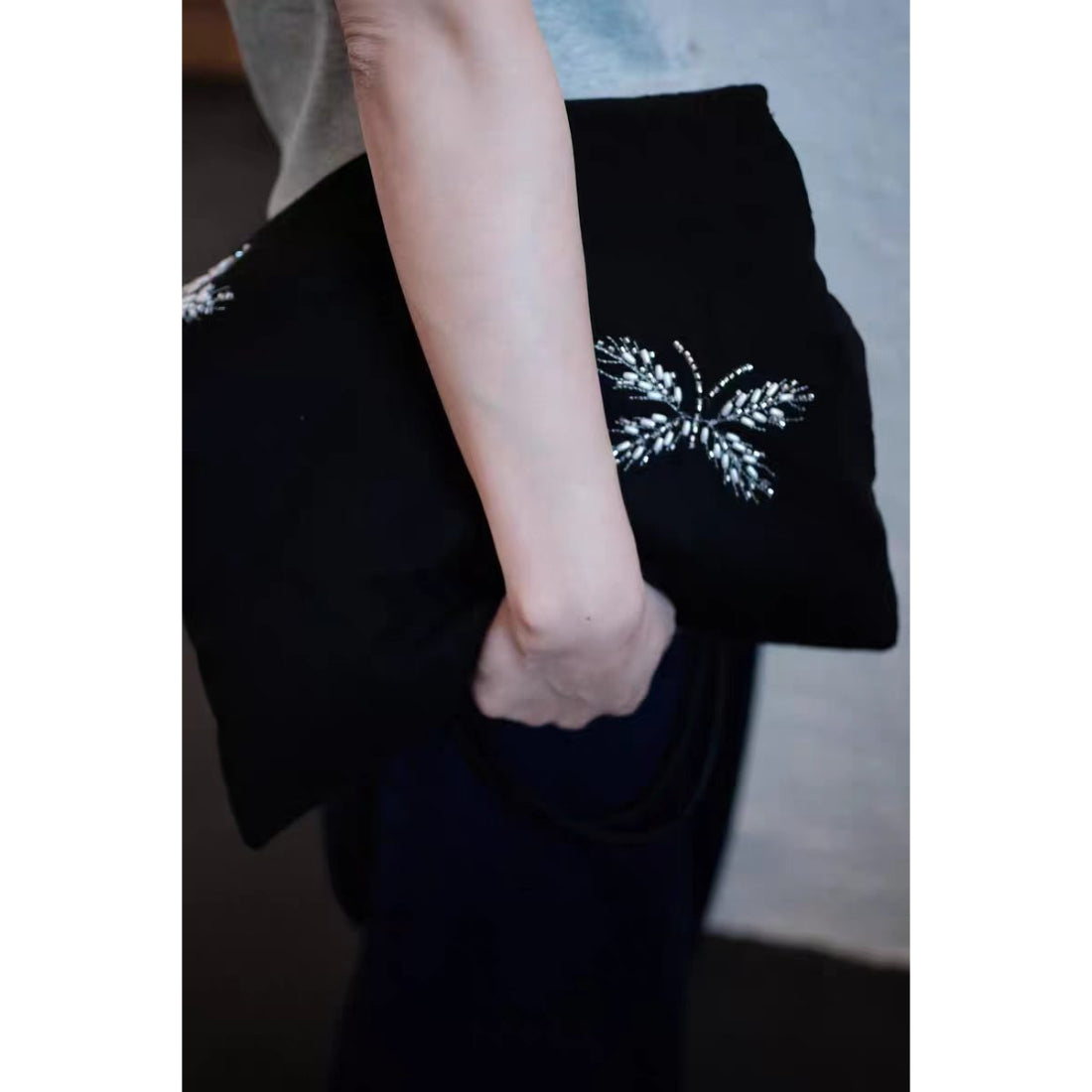 Black tote bag displayed on white background with beaded embellishments