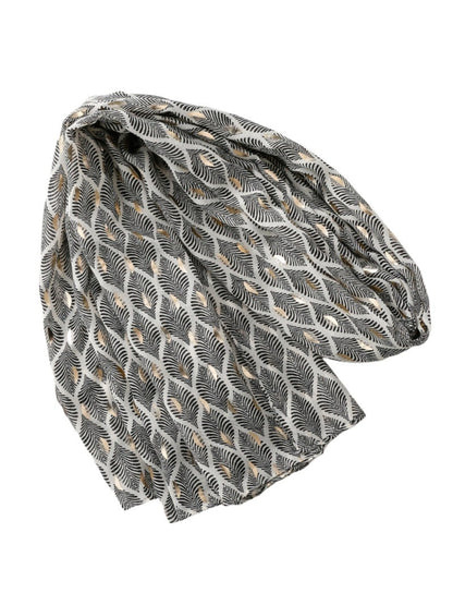 Model holding the scarf to display its lightweight and soft feather pattern fabric