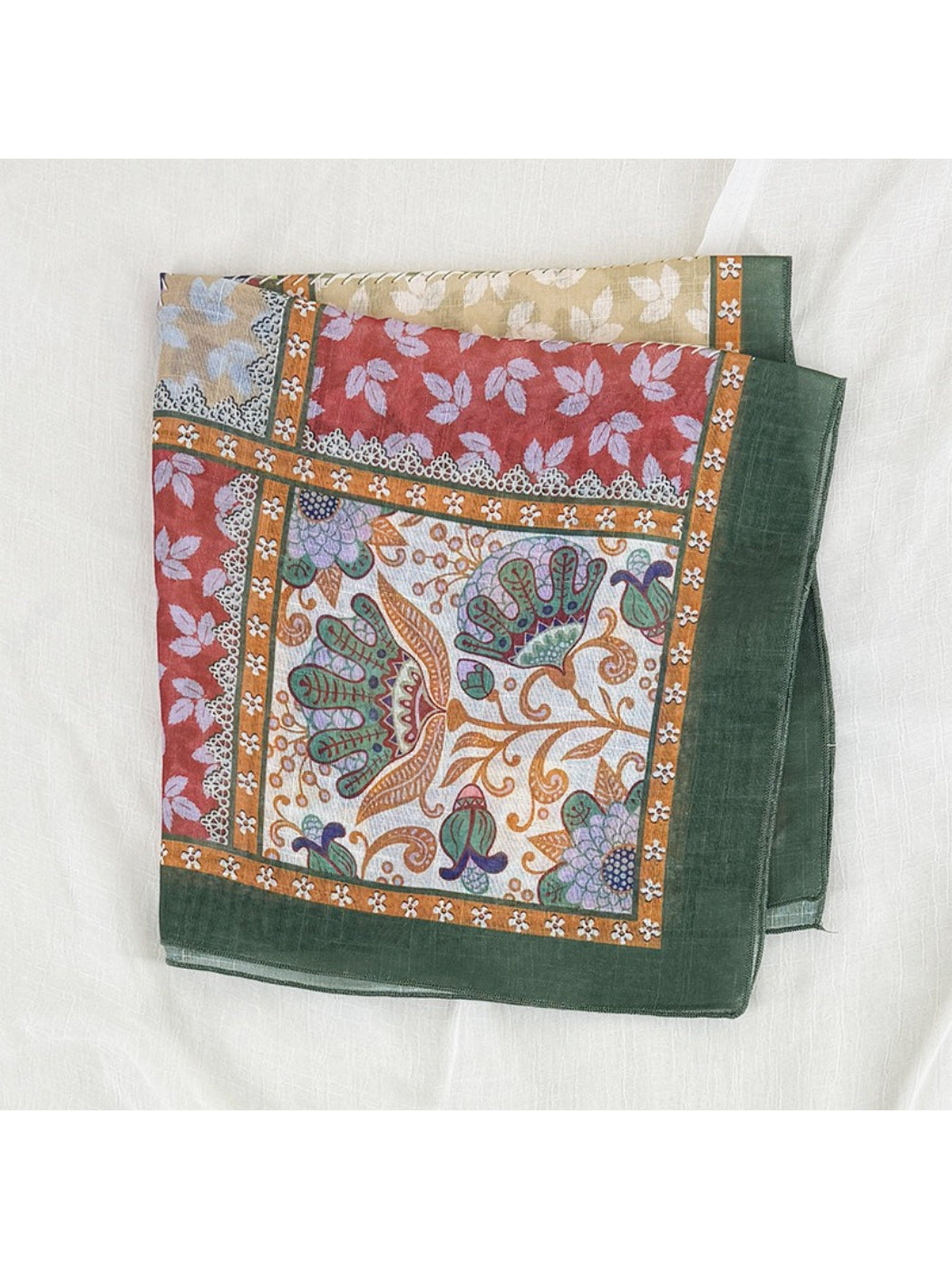 Scarvii scarf folded neatly with visible floral border and patchwork details