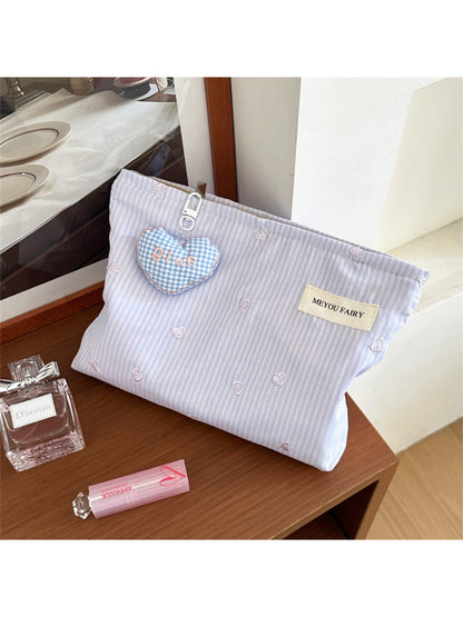 Cosbai cosmetic bag with heart pattern next to makeup brushes