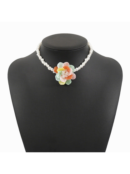 White beaded flower necklace coiled neatly with focus on flower centerpiece