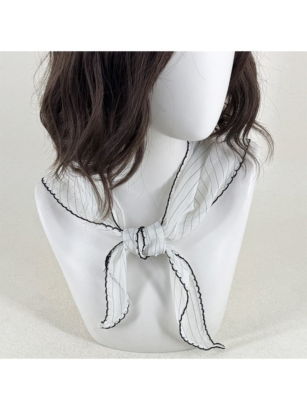 Scarvii pleated triangle scarf with black and white contrast trim laid flat
