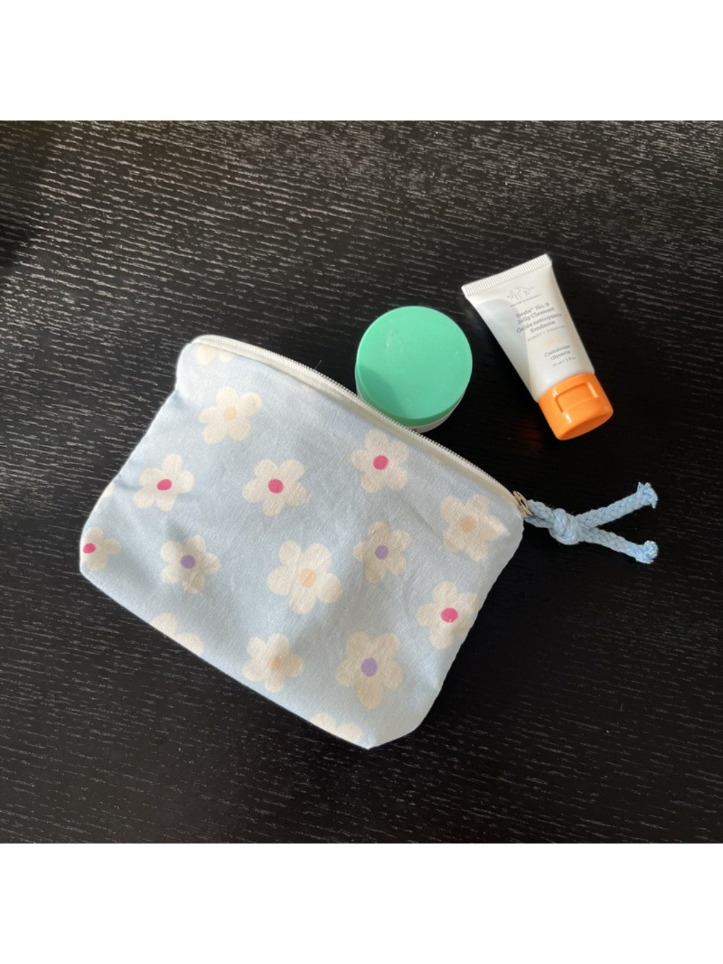 Cosbai mini pouch bag placed on a flat surface with floral pattern visible