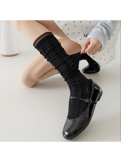 Close-up of Rufia soft cable knit pattern on cream knee high sock