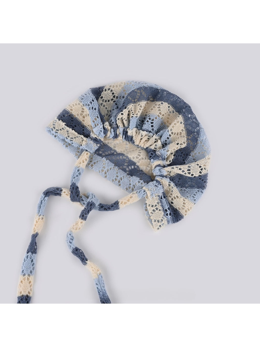 Side view of Haila hollow out lace up knit slouchy beanie highlighting slouchy fit and lace-up design