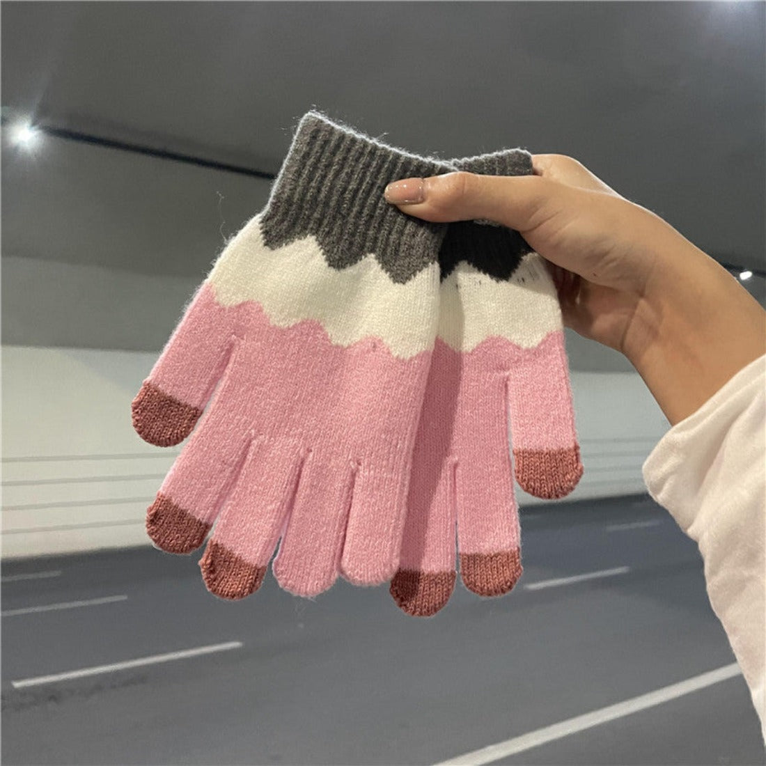 Knitting patchwork touchscreen gloves worn by model using smartphone