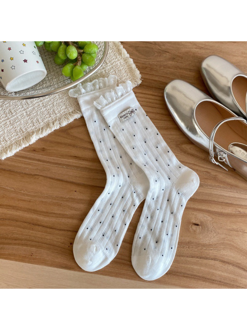 Beige socks with black polka dots folded neatly on a white surface