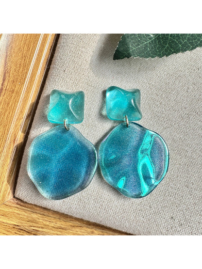 Ocean blue drop earrings with silver hooks displayed on a white background