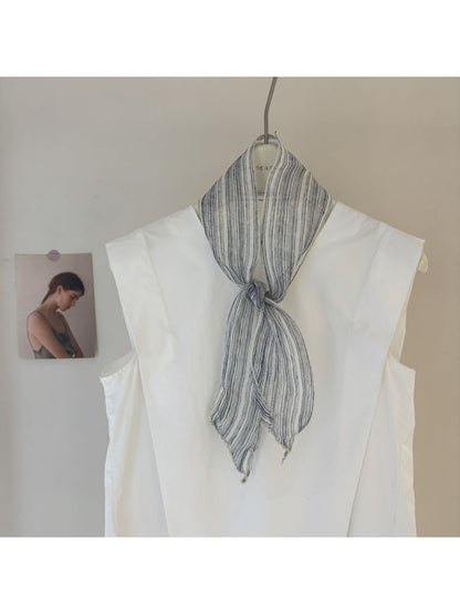 Scarvii skinny scarf displayed on wooden surface showing gingham and stripe print