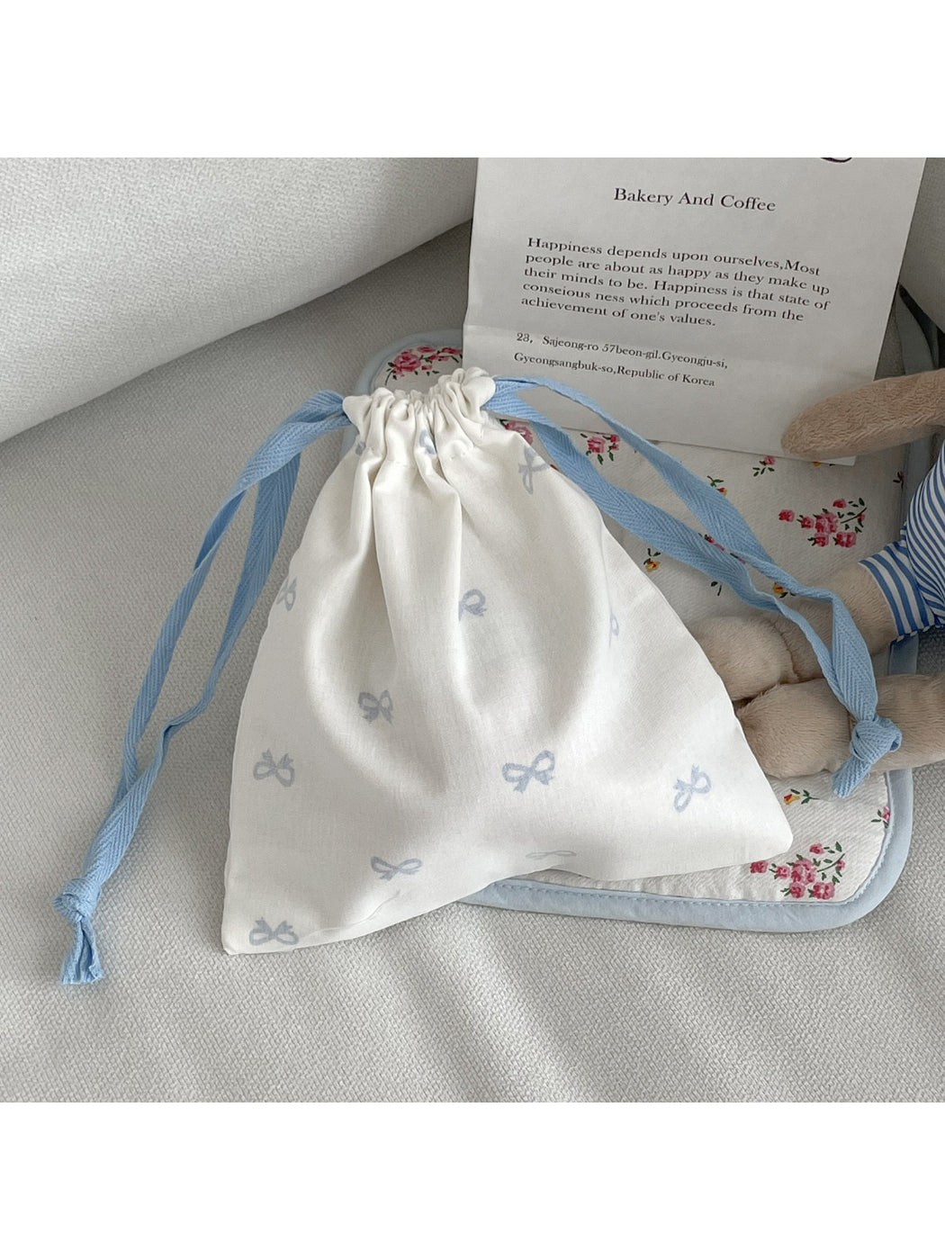 Cosbai drawstring pouch with bow pattern hanging by its strings