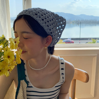 Side view of beige crochet hairband showing detailed hollow-out pattern