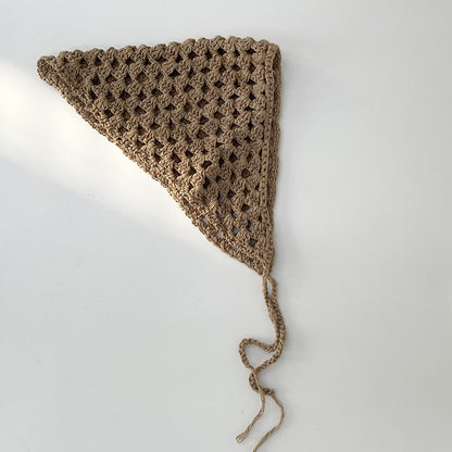 Close-up of crochet stitches and hollow-out details on beige hairband