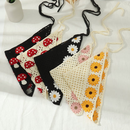 Crochet hairband wrapped around a hand showing sunflower and mushroom designs