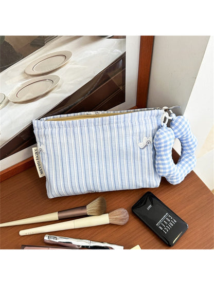 Side view of striped cosmetic bag highlighting fabric texture