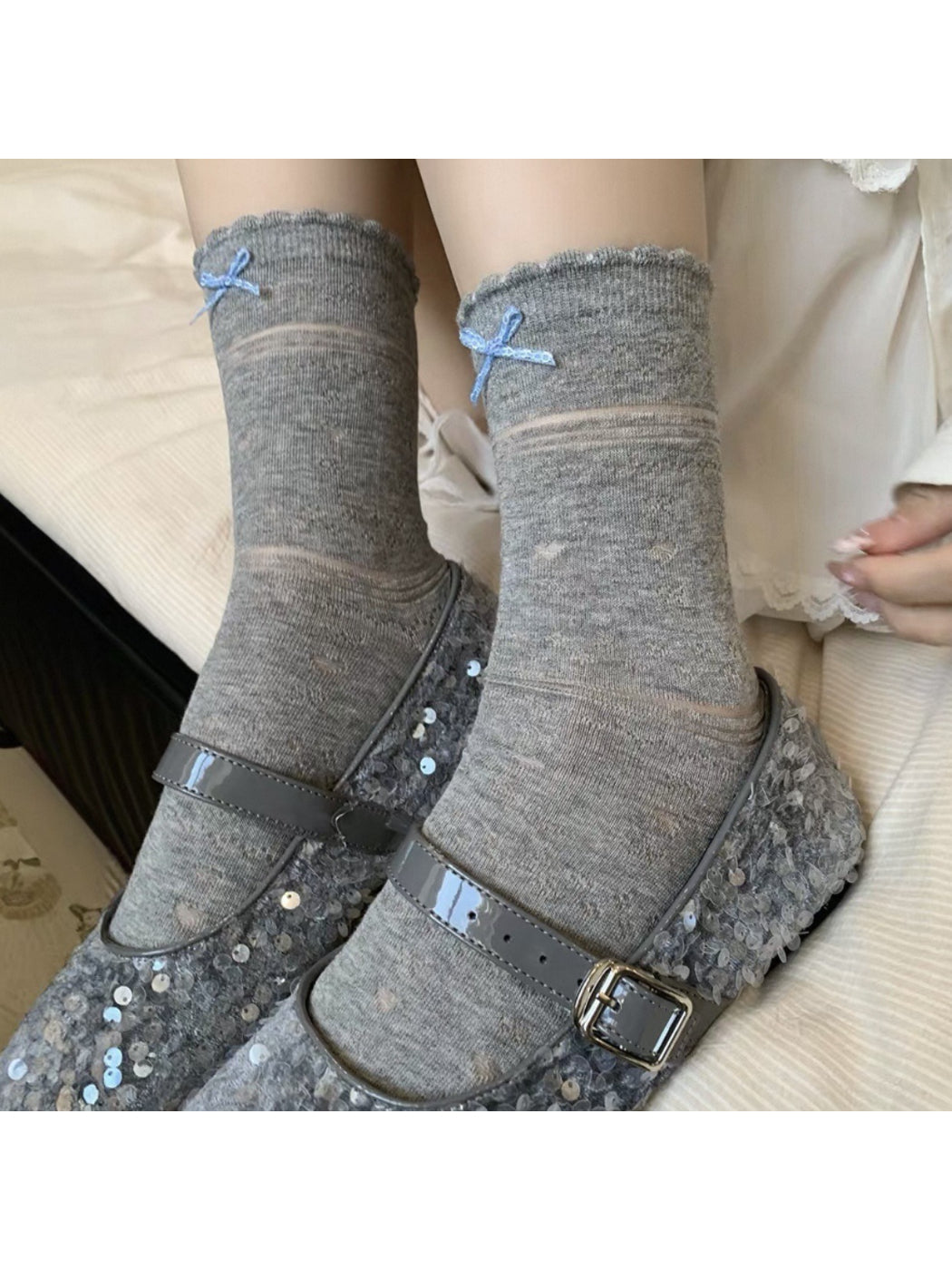 Close-up of ribbon tied in a bow on soft blue socks