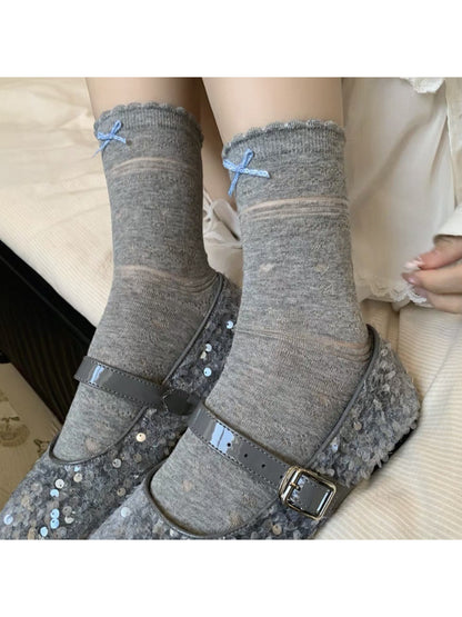 Close-up of ribbon tied in a bow on soft blue socks