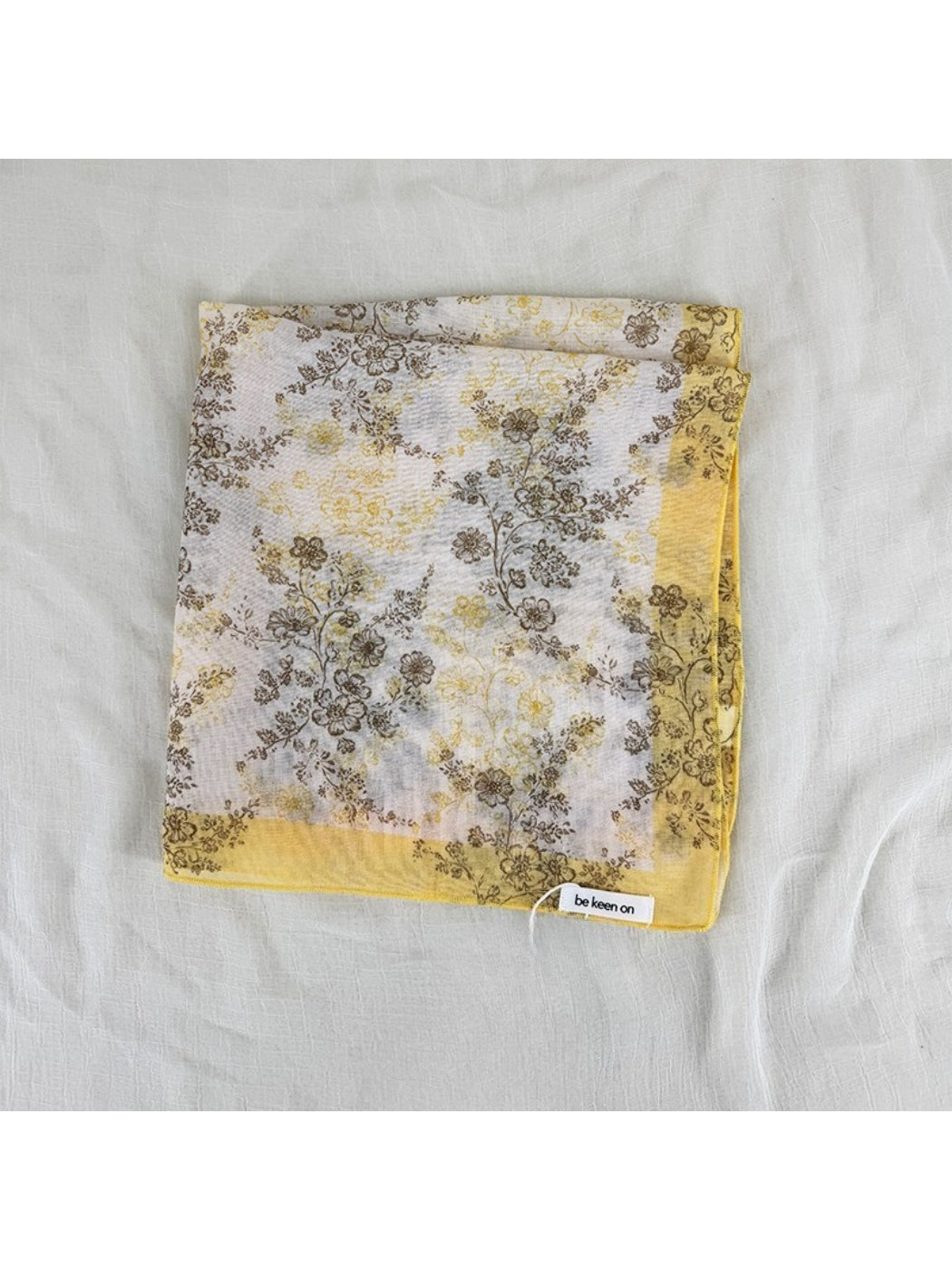 Scarf laid flat displaying full blossom print with soft pastel colors