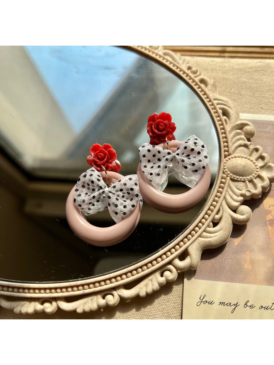 Close-up of Earwish Rose Bow Hoop Earrings with pink bow detail on gold hoops