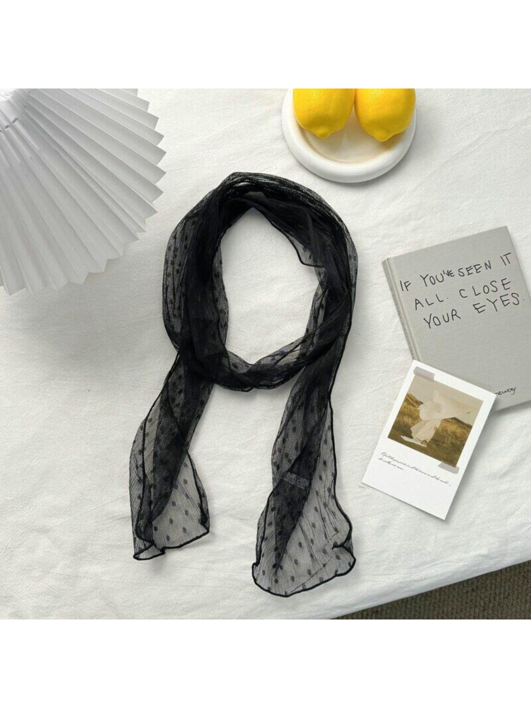Close-up of the black scarf fabric showing white dotted pattern and texture