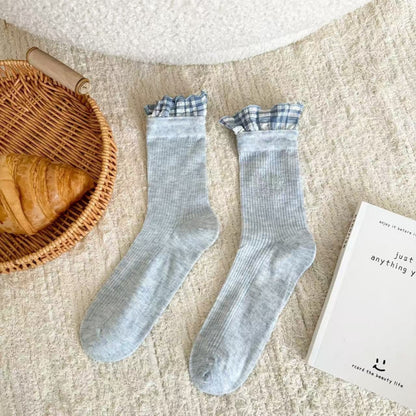 Model wearing Rufia ruffle pastel mid-calf socks paired with casual shoes