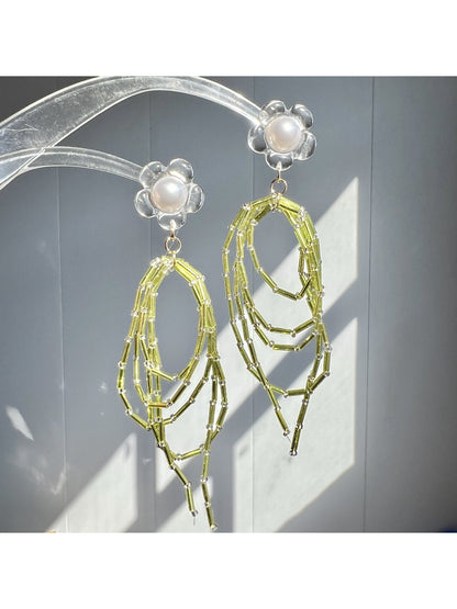 Close-up of Earwish green bead dangle earrings with silver hooks on white background