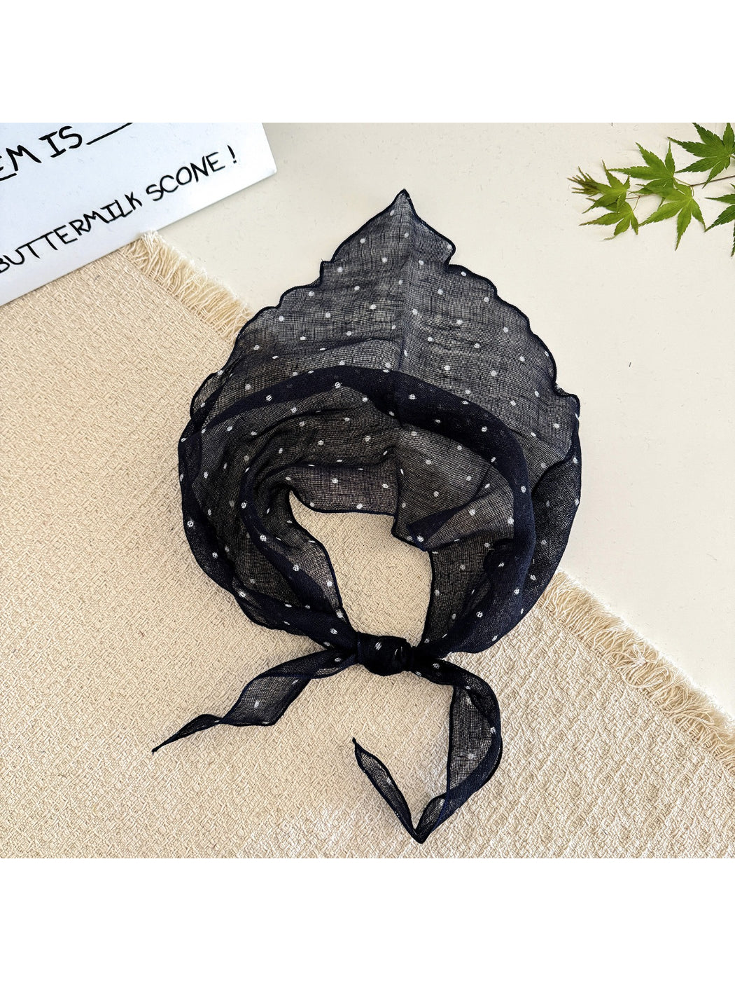 Flat lay of Scarvii soft textured polka dot head scarf showing fabric detail