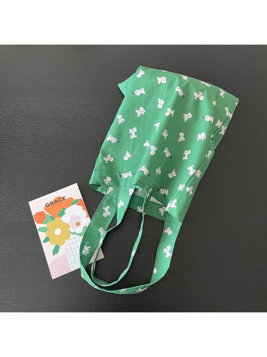 Green puppy slouch tote bag held by model, showing size and fit