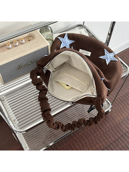Close-up of star patch on beige Cosbai slouchy shoulder bag