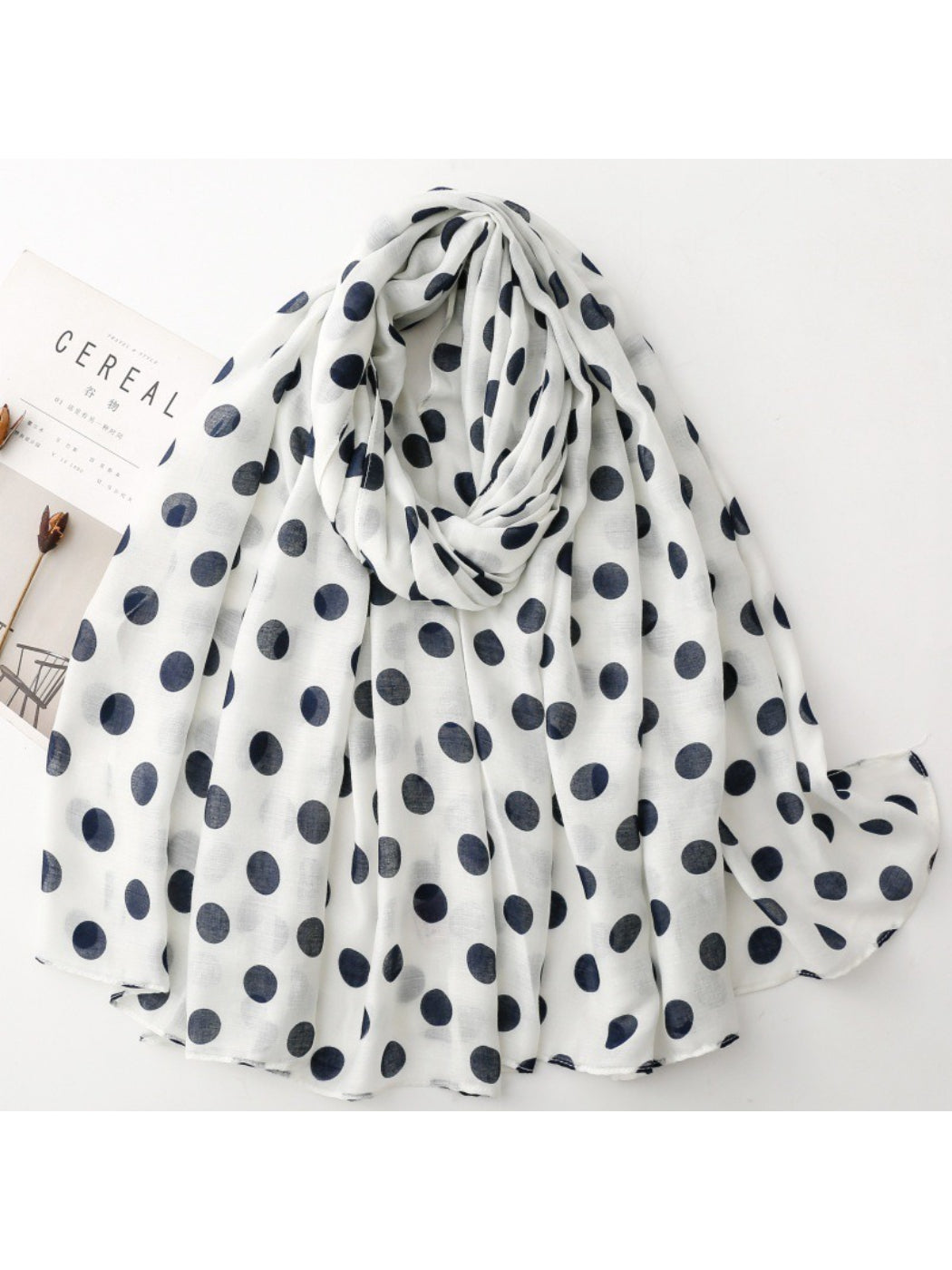 Close-up of Scarvii scarf fabric texture with white polka dots on black background