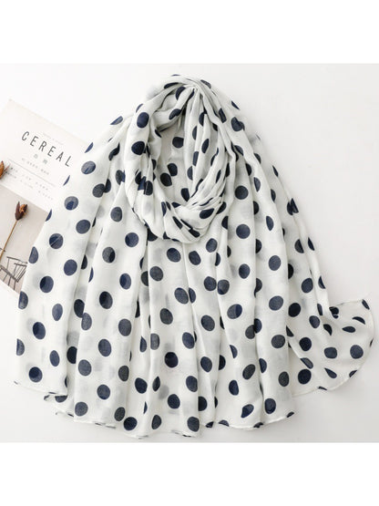 Close-up of Scarvii scarf fabric texture with white polka dots on black background