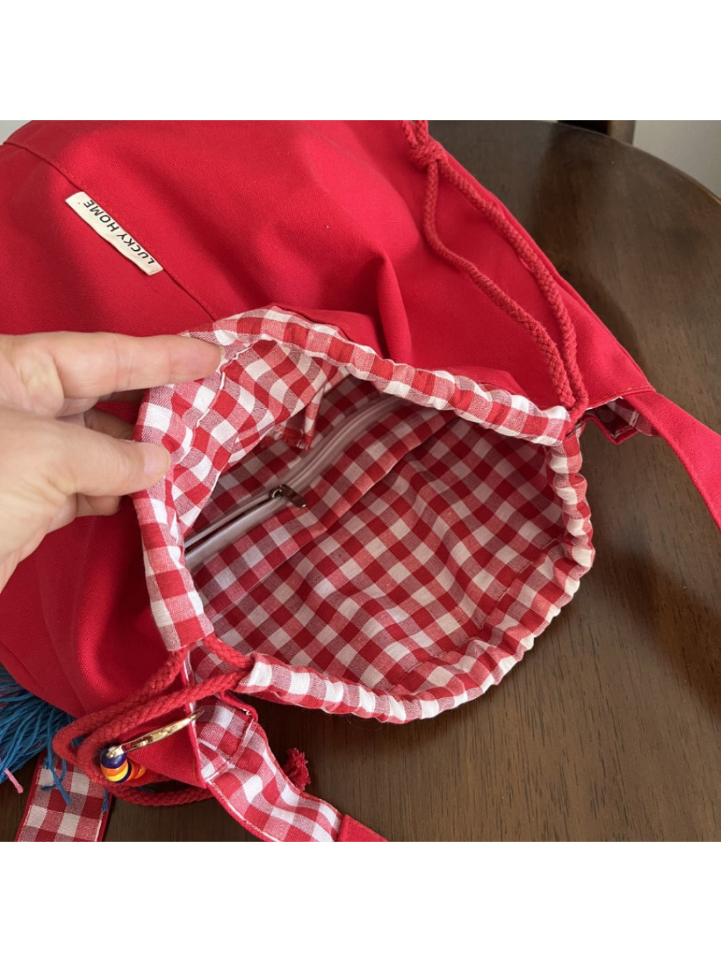 Cosbai bucket bag with tassel detail close-up on gingham trim