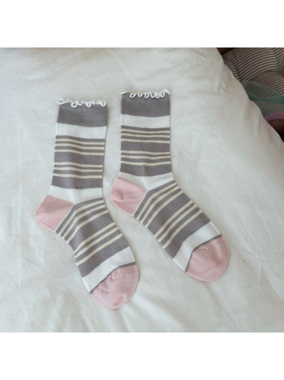 Rufia socks paired with casual shoes, emphasizing the wavy cuff design