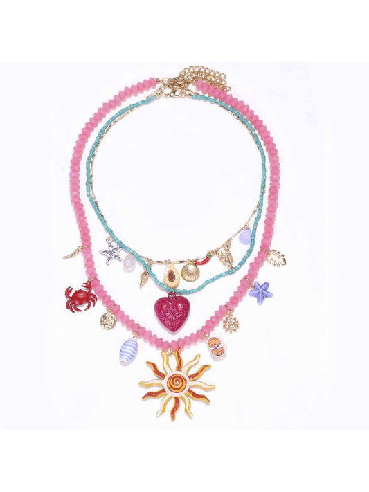 Neckit layered charm necklace featuring sun and heart detail on a white background