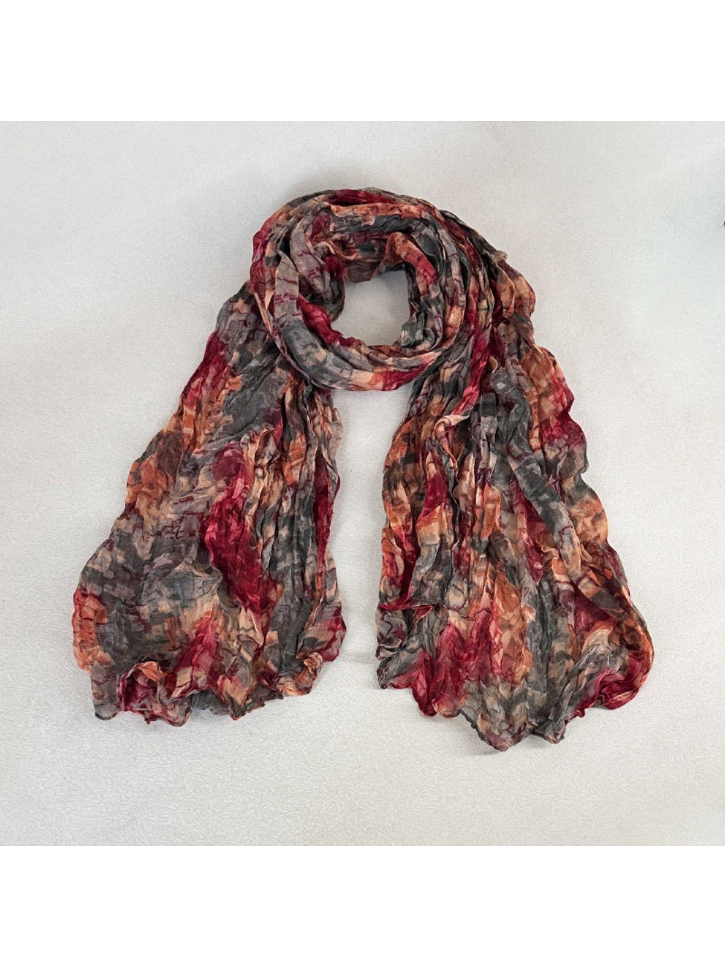 Scarvii scarf partially rolled to reveal layered painterly print and fabric texture
