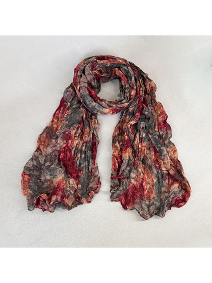 Scarvii scarf partially rolled to reveal layered painterly print and fabric texture