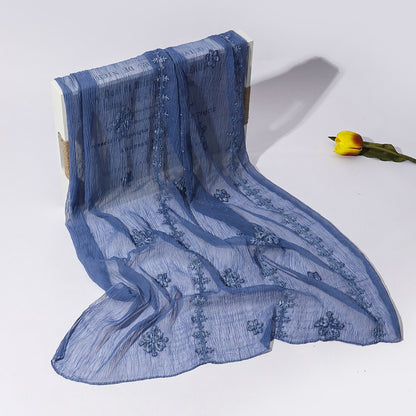 Scarvii scarf styled on a wooden surface highlighting blossom stitch texture