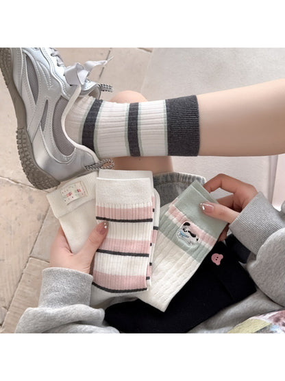 Pair of Rufia everyday crew socks with colorful playful stripe pattern on white background