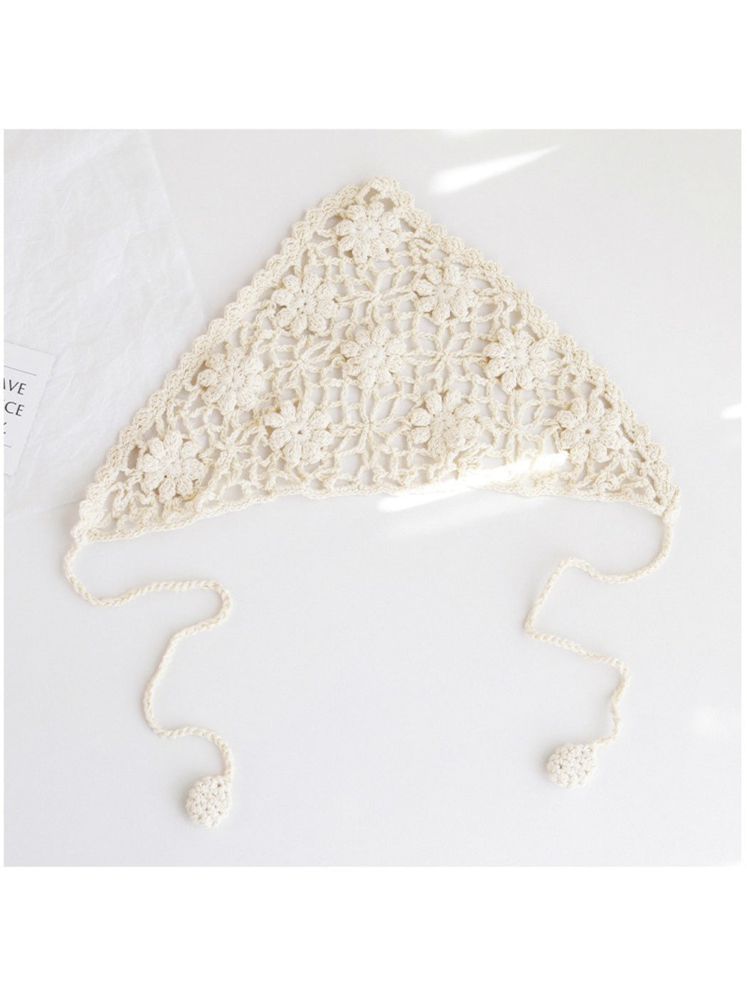 Close-up of cream crochet headband showing detailed floral pattern