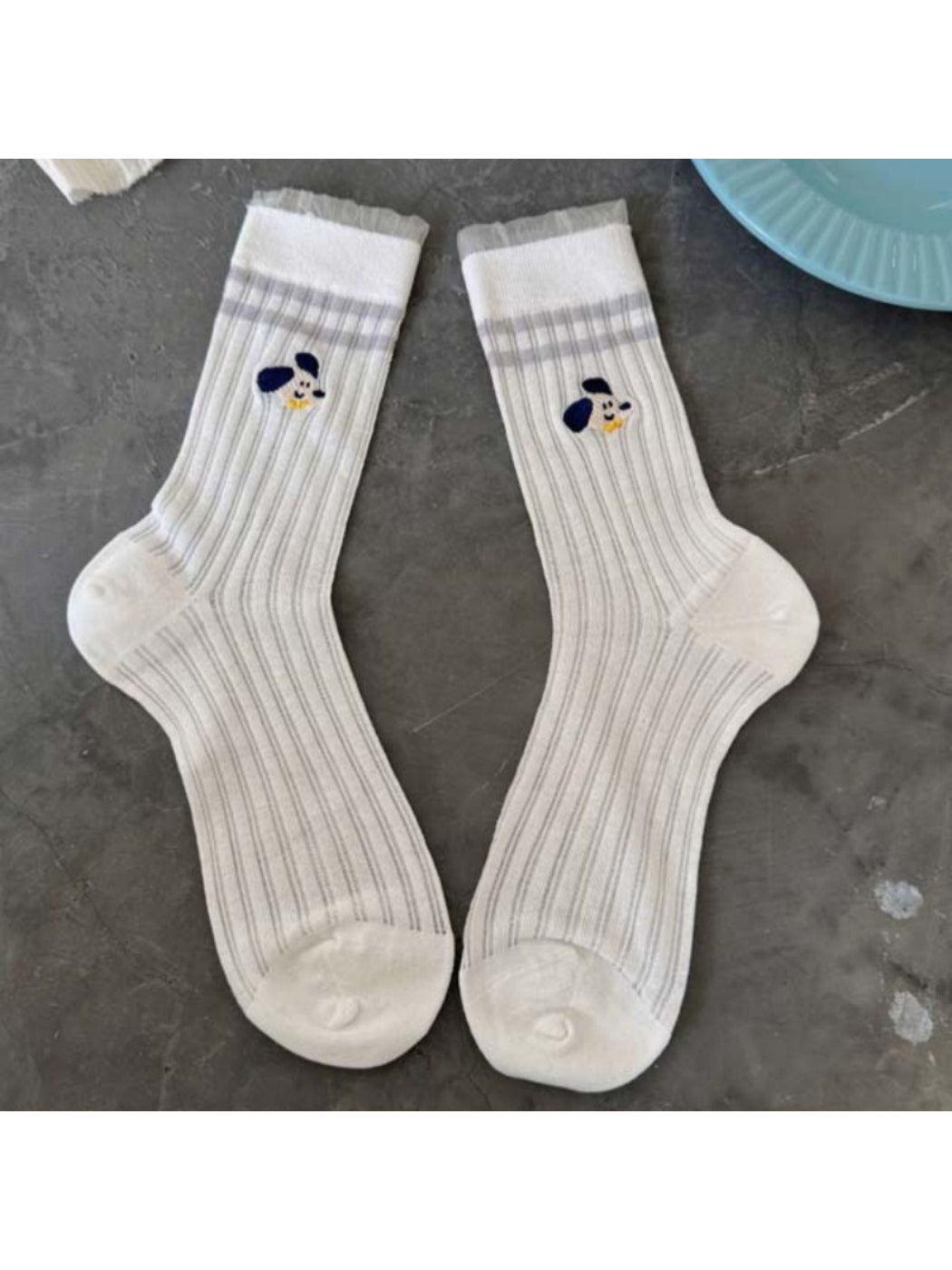 Pair of Rufia Playful Pup socks laid flat displaying full dog pattern design