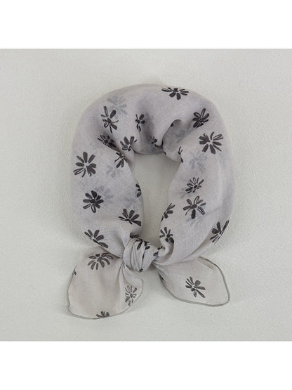 Close-up of Scarvii scarf fabric with small daisy flowers in yellow and white