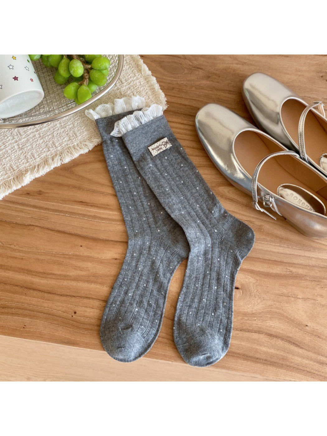 Flat lay of beige ribbed socks with evenly spaced black polka dots