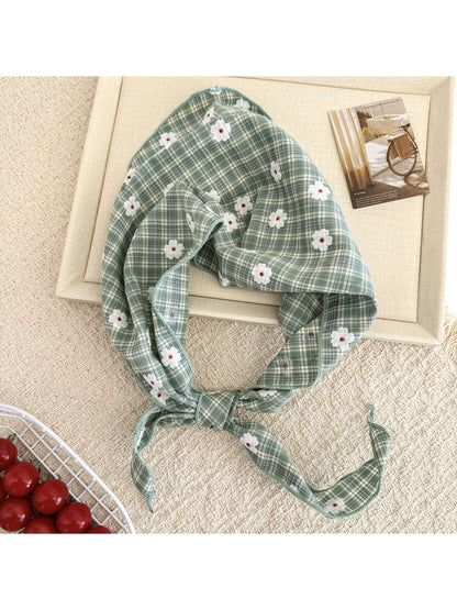 Close-up of plaid fabric with white daisy prints on soft hair tie scarf