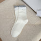 Side view of Rufia ribbed crew socks highlighting ruffle edge