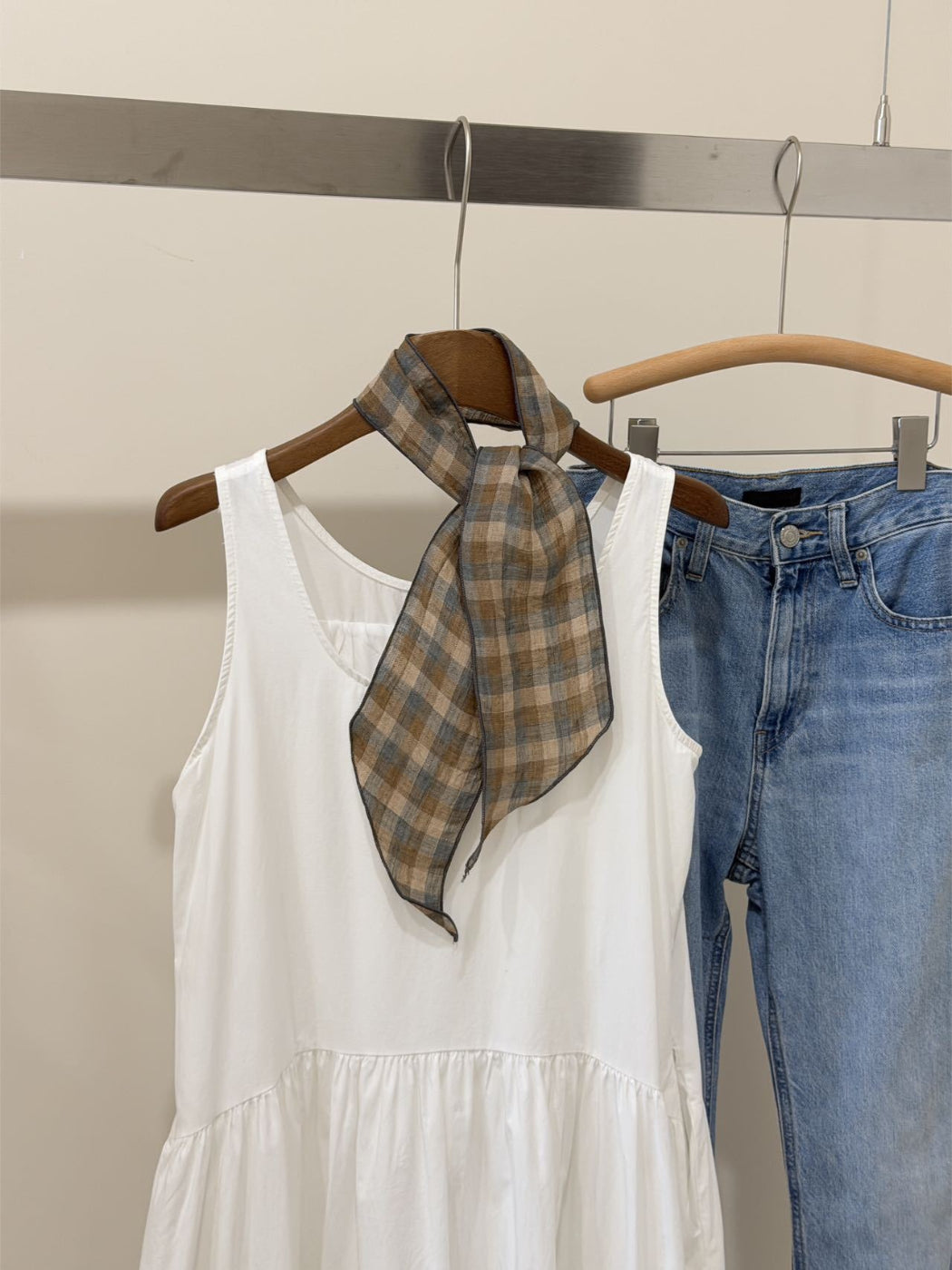 Plaid slim skinny scarf folded neatly on a wooden surface