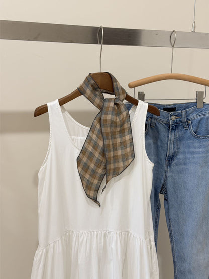 Plaid slim skinny scarf folded neatly on a wooden surface