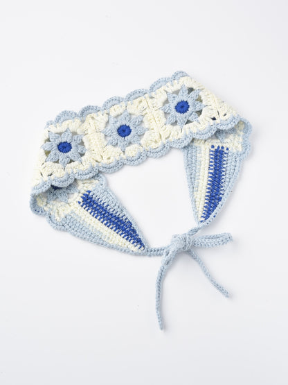 Model styling long hair with crochet flower hairband in natural light