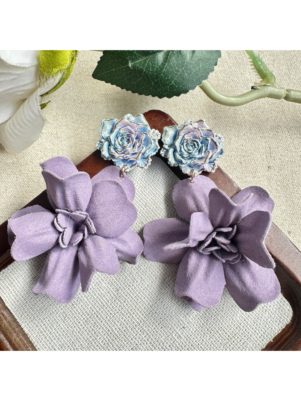 Model wearing Earwish purple floral drop earrings showcasing length and style